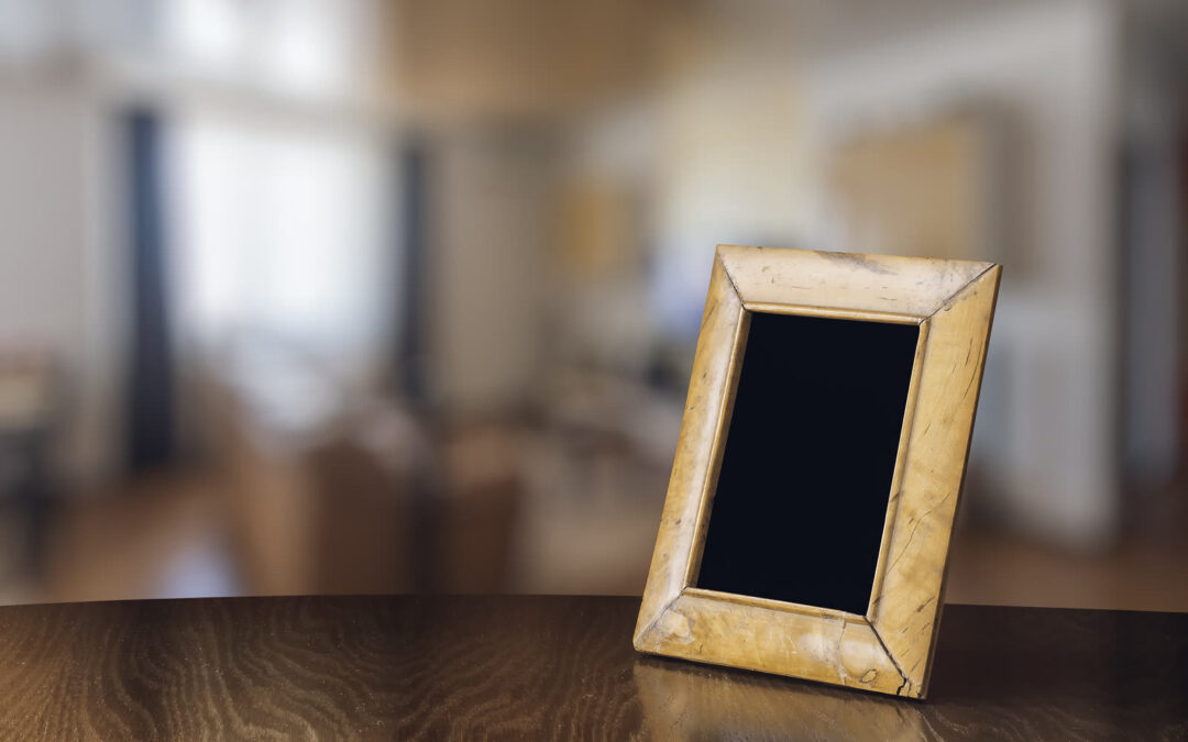 Un viejo marco de fotos de madera descansa sobre la mesa del comedor de una tranquila casa familiar.